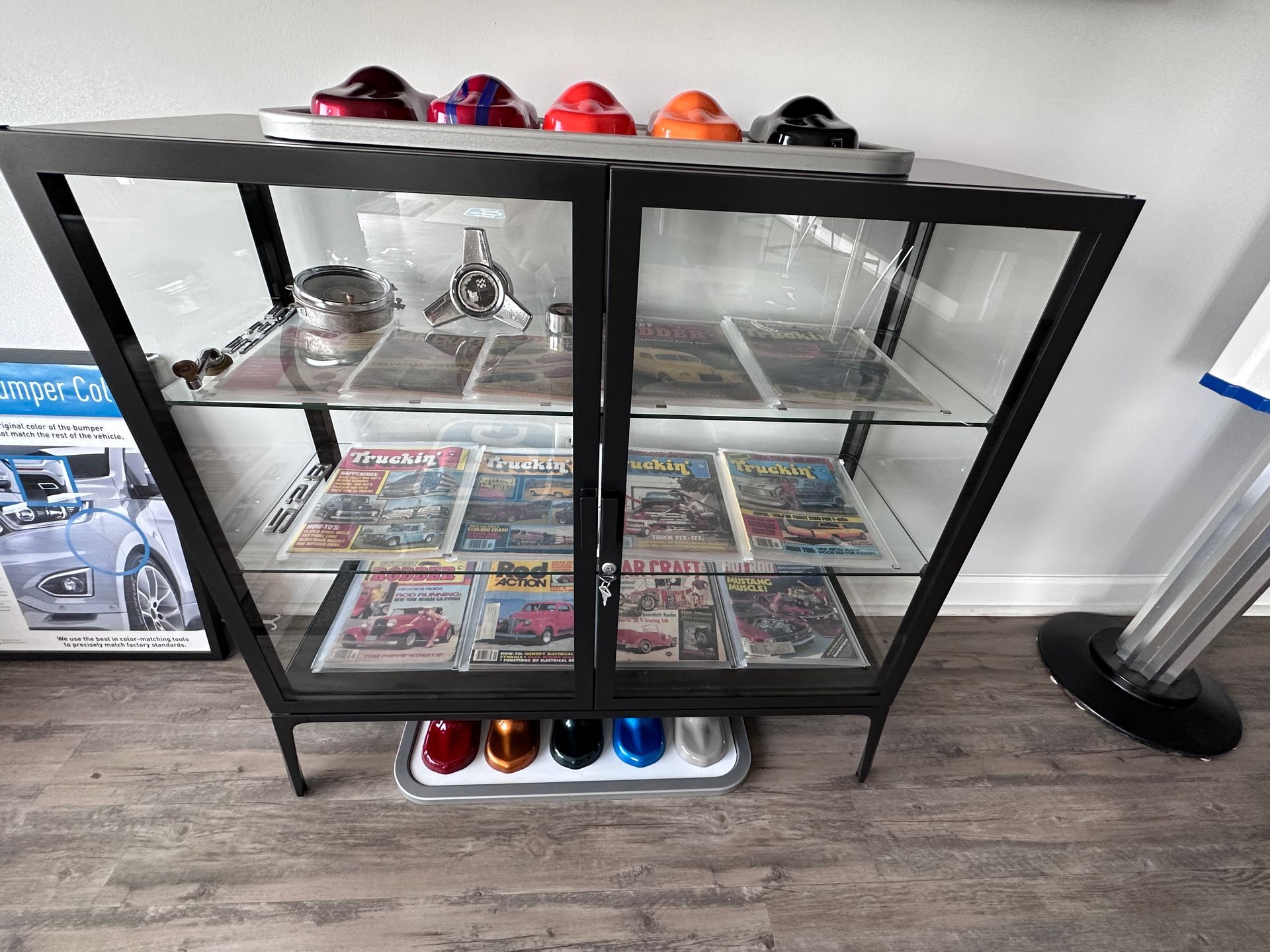 A glass display case filled with cars and magazines