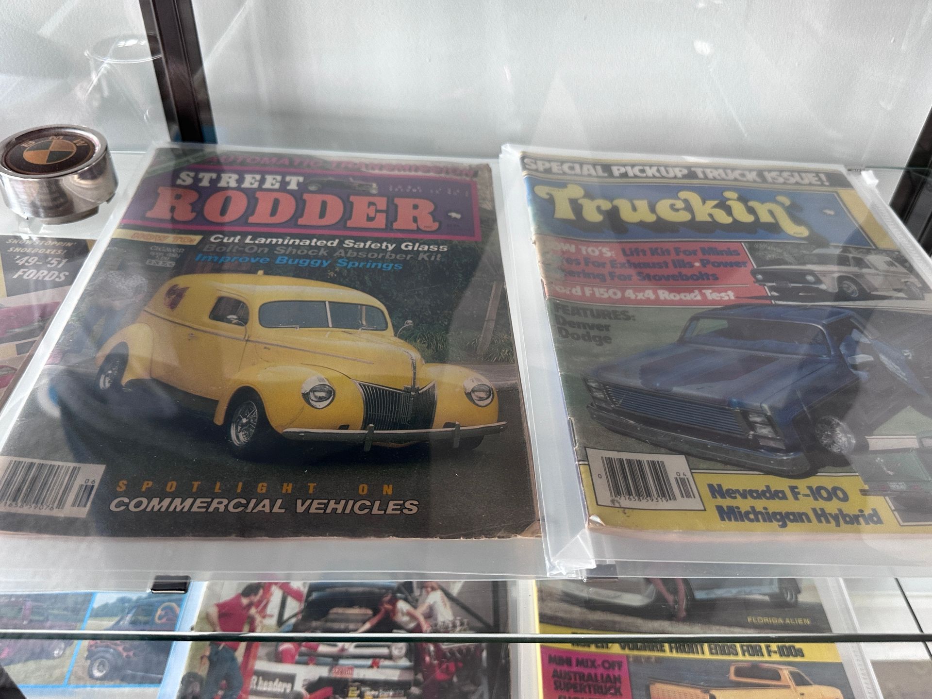 Two magazines on a glass shelf one of which is titled street rodder