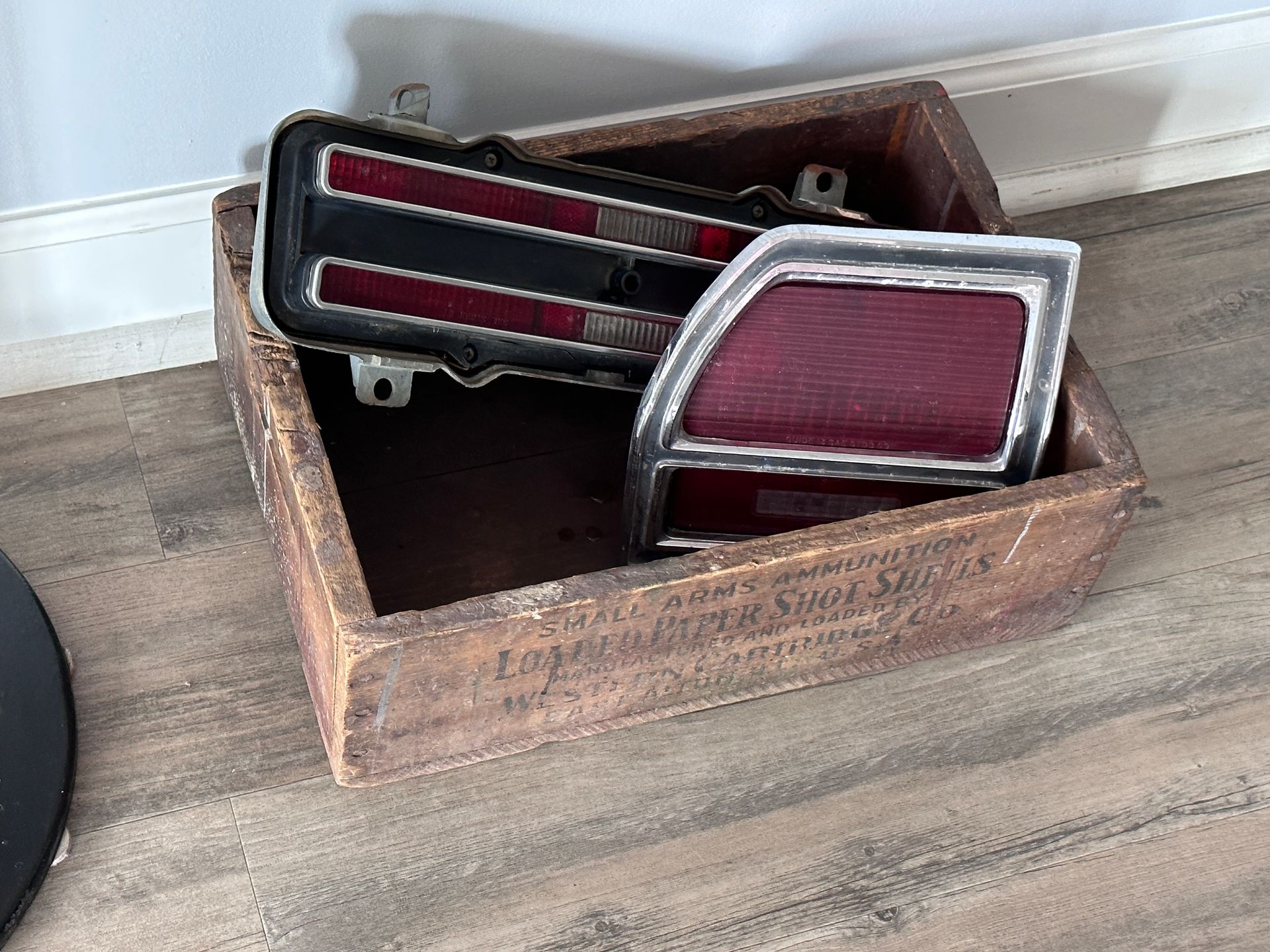 A wooden box filled with a bunch of car parts