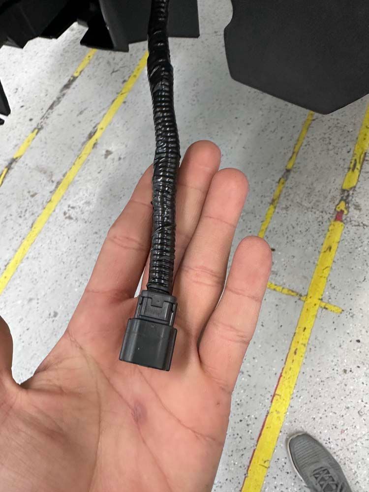 A person is holding a black cable in their hand.