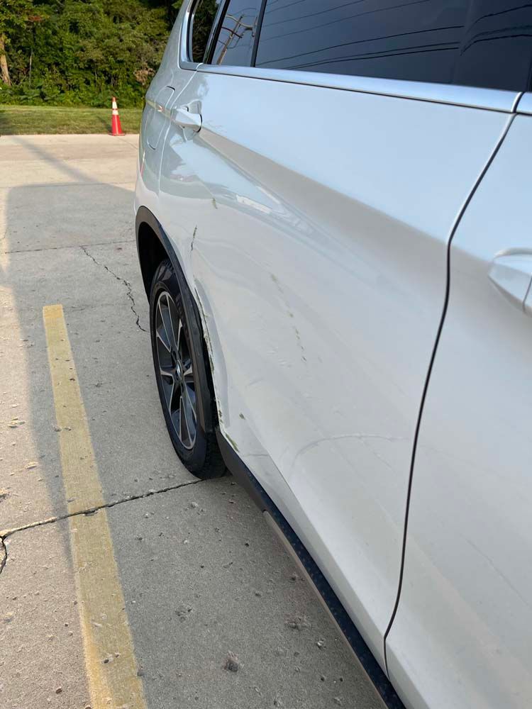 A white car is parked in a parking lot.