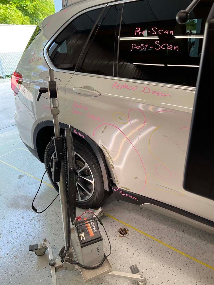 A white car is sitting on a stand in a garage.