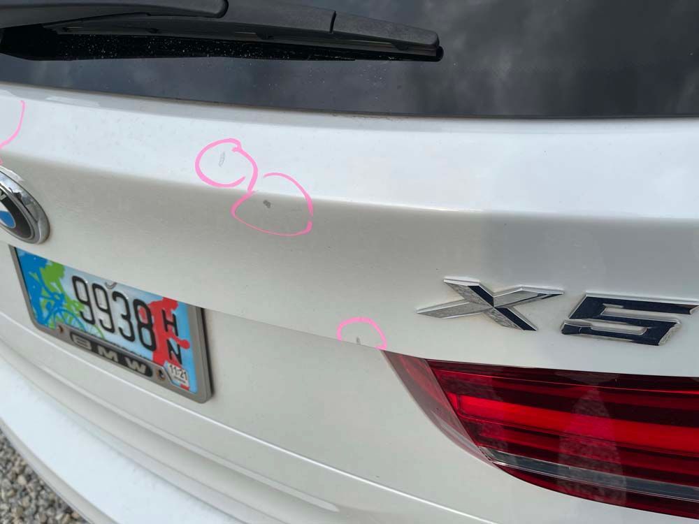 A white bmw x5 with a license plate that says 99398