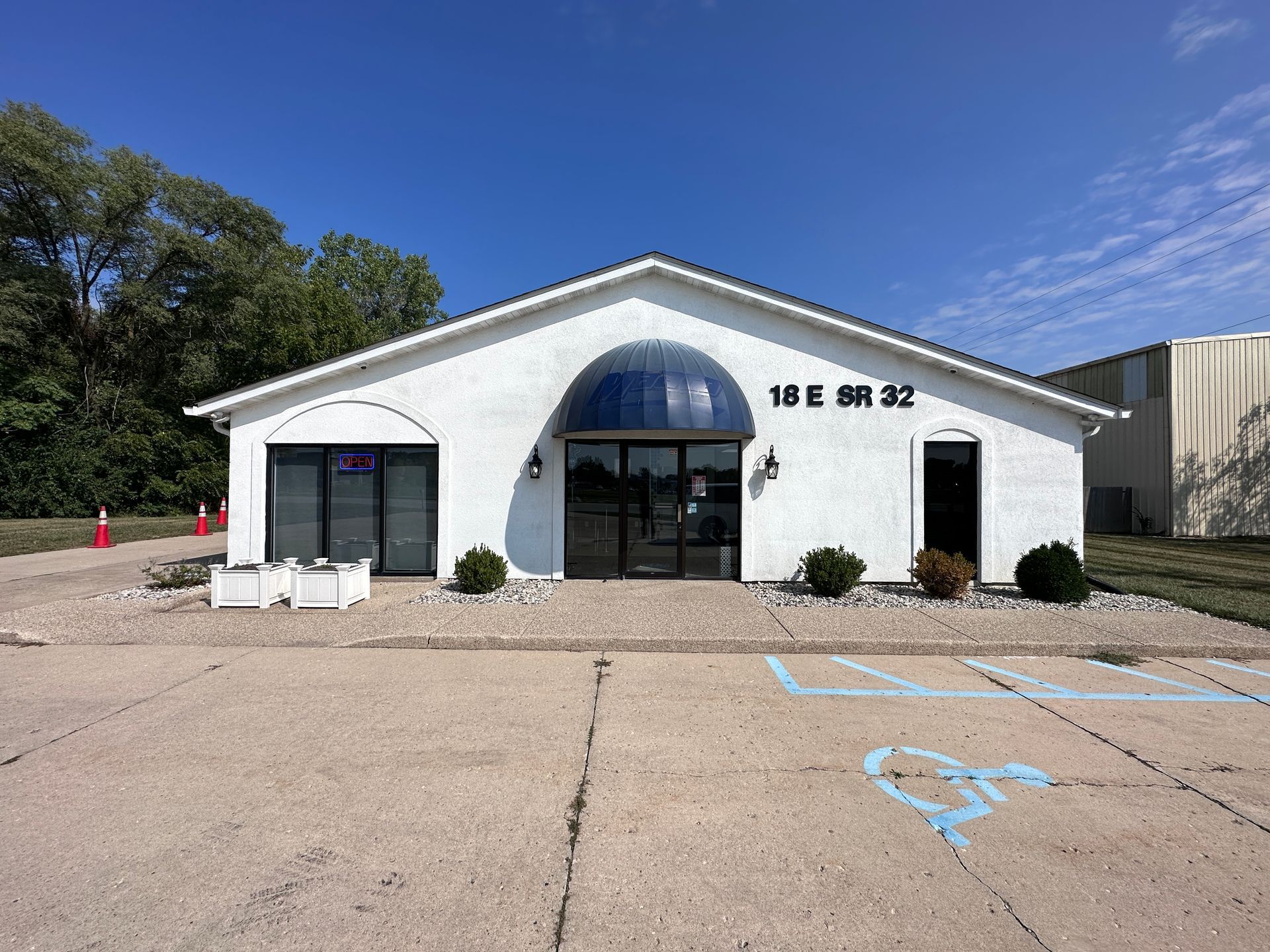 A white building with a handicapped parking spot in front of it