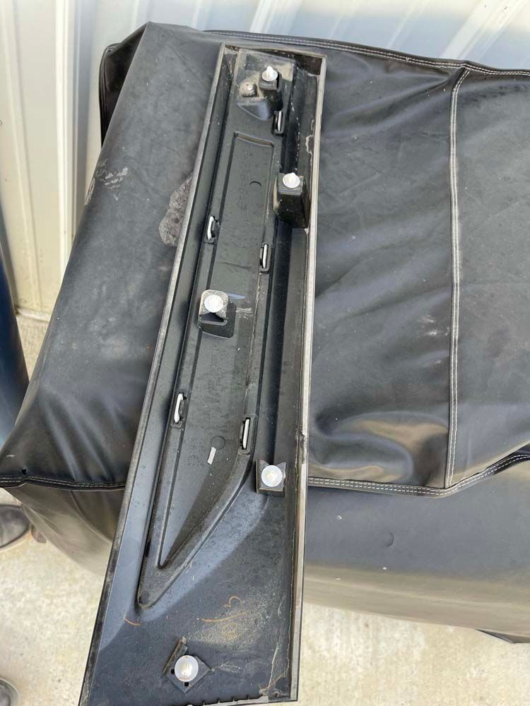 A black piece of plastic is sitting on top of a black bag.