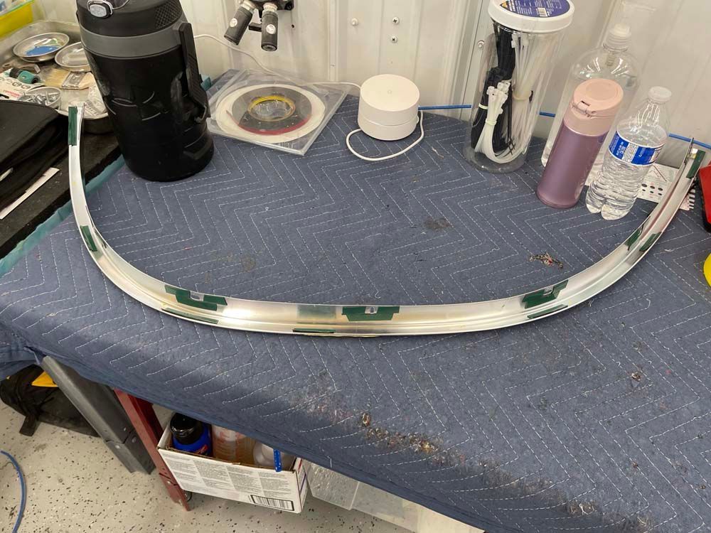 A piece of metal is sitting on top of a blue table.