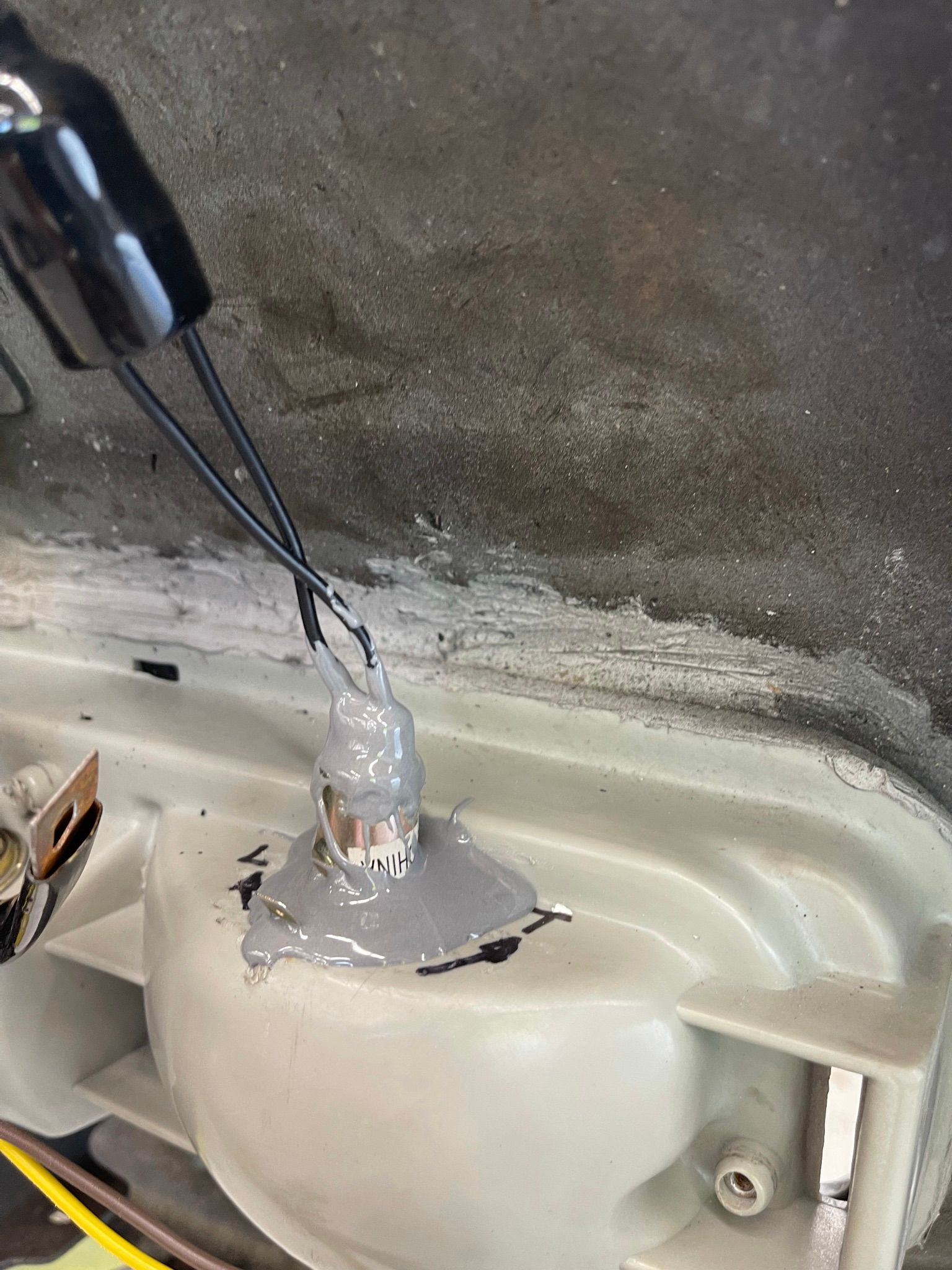 A close up of a white object with a wire sticking out of it.