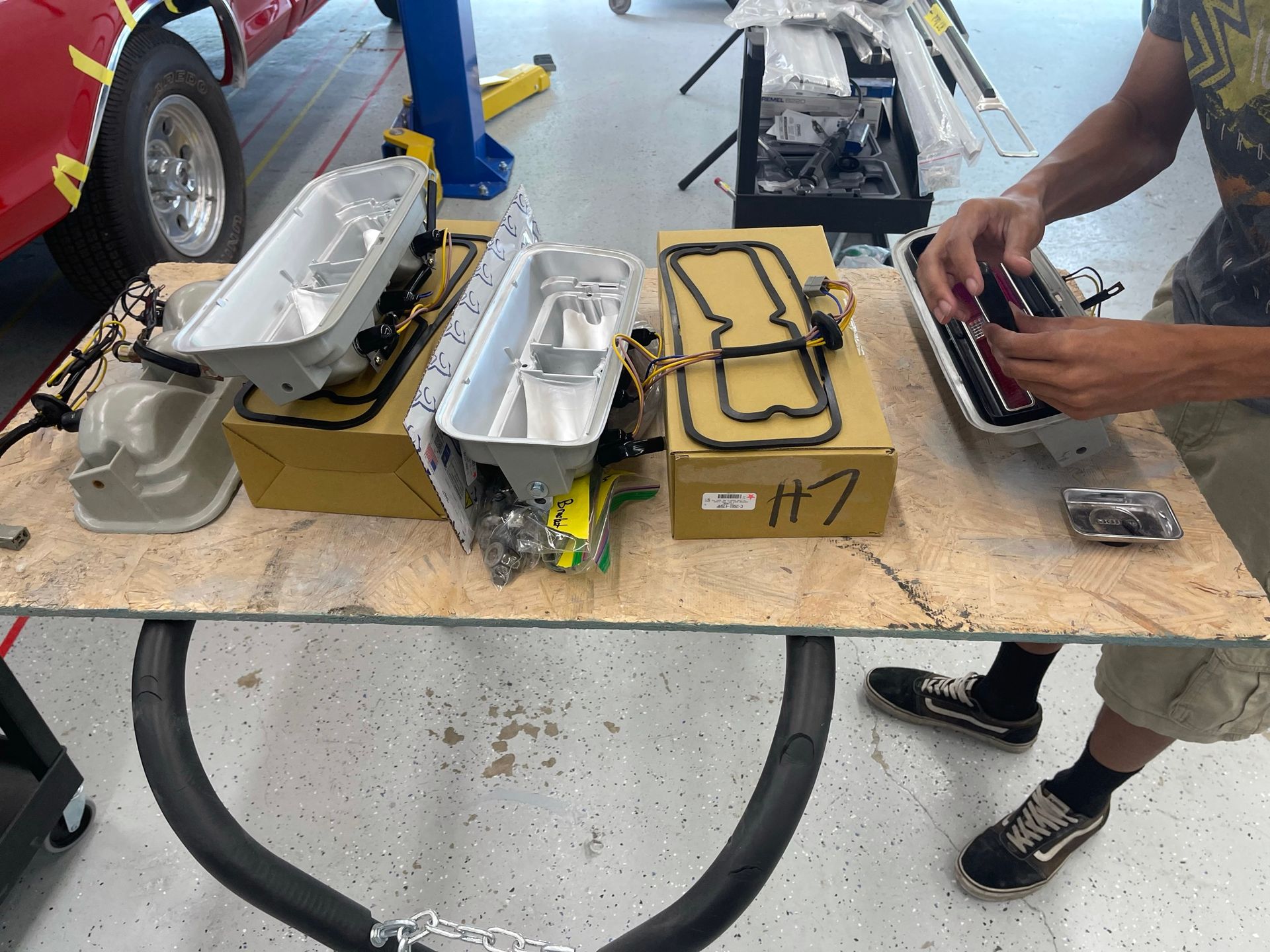 A man is working on a car engine in a garage.