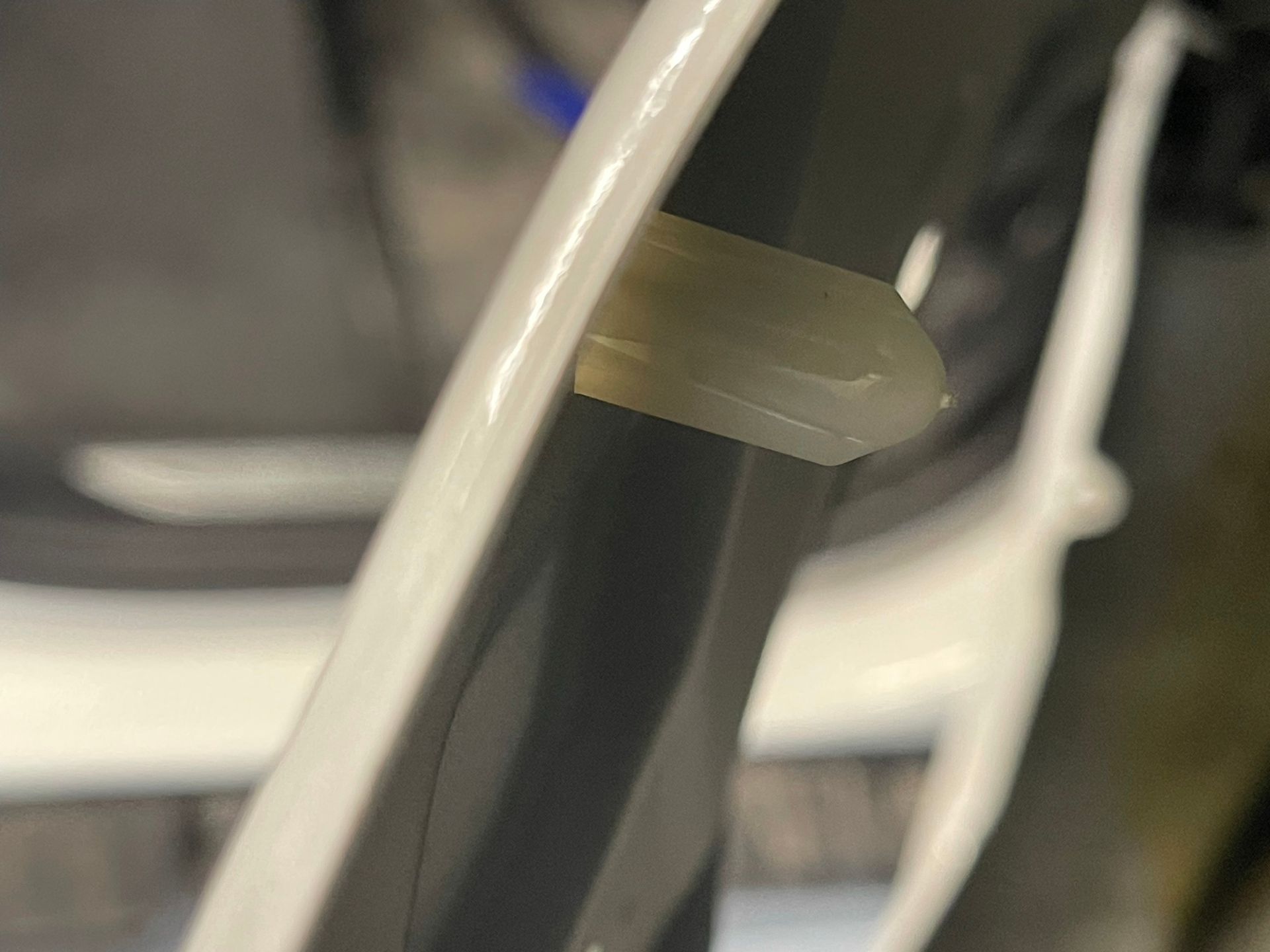 A close up of a plastic clip on a bicycle wheel.