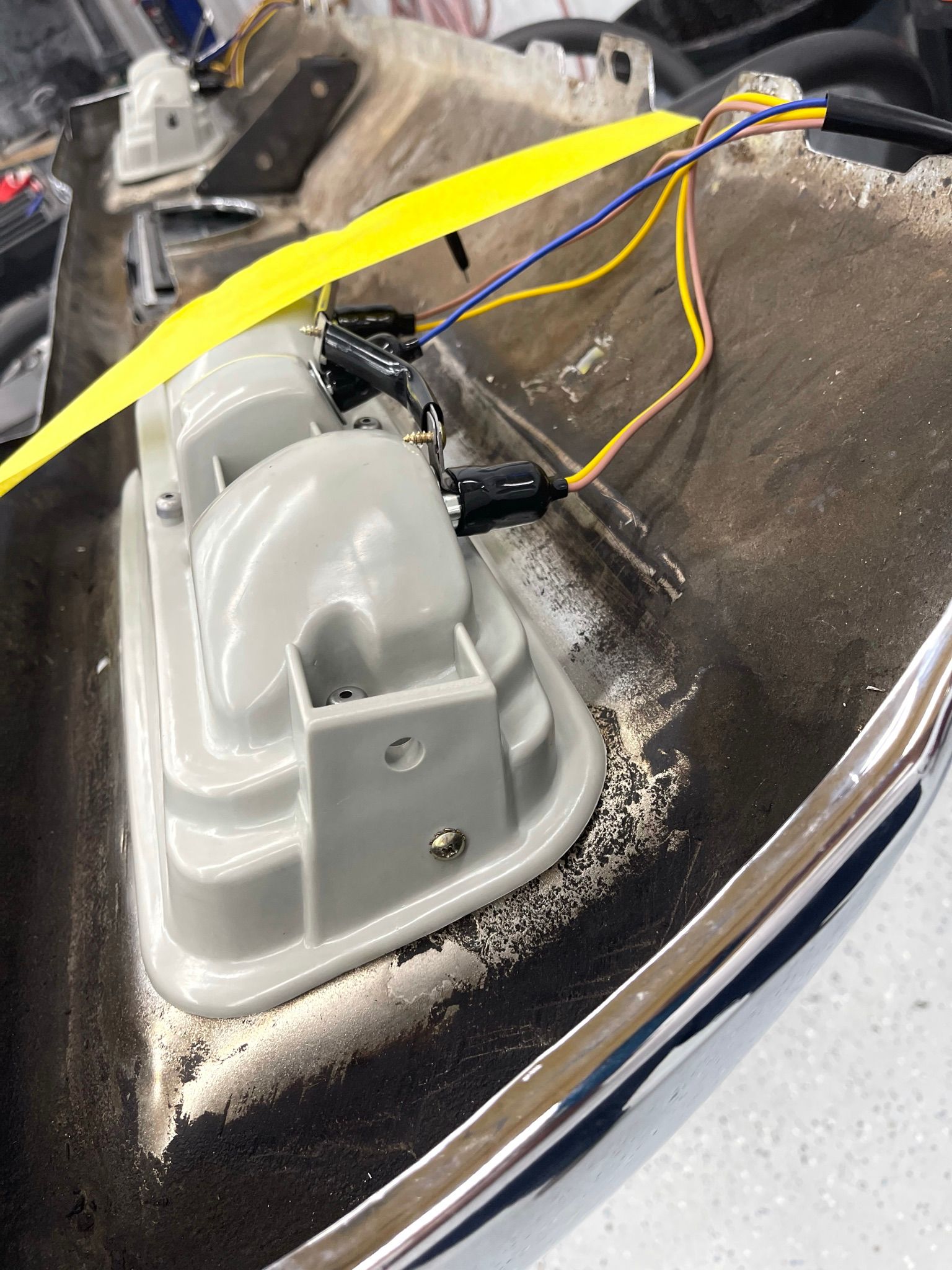 A close up of a car hood with wires coming out of it.