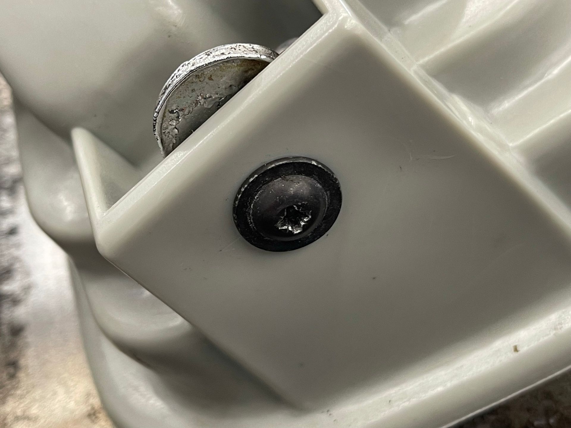 A close up of a screw on a piece of plastic.