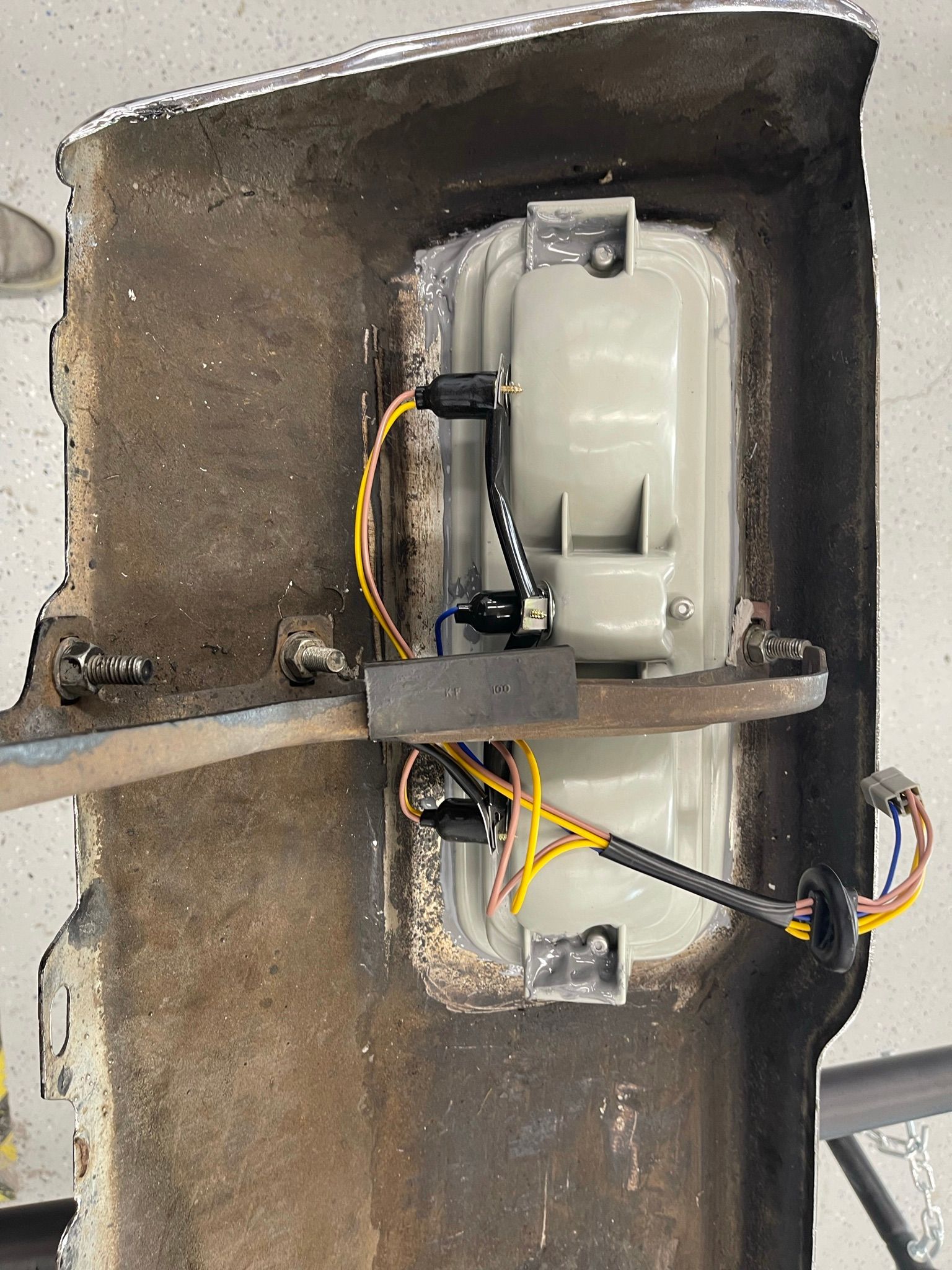 A close up of a car bumper with wires coming out of it.