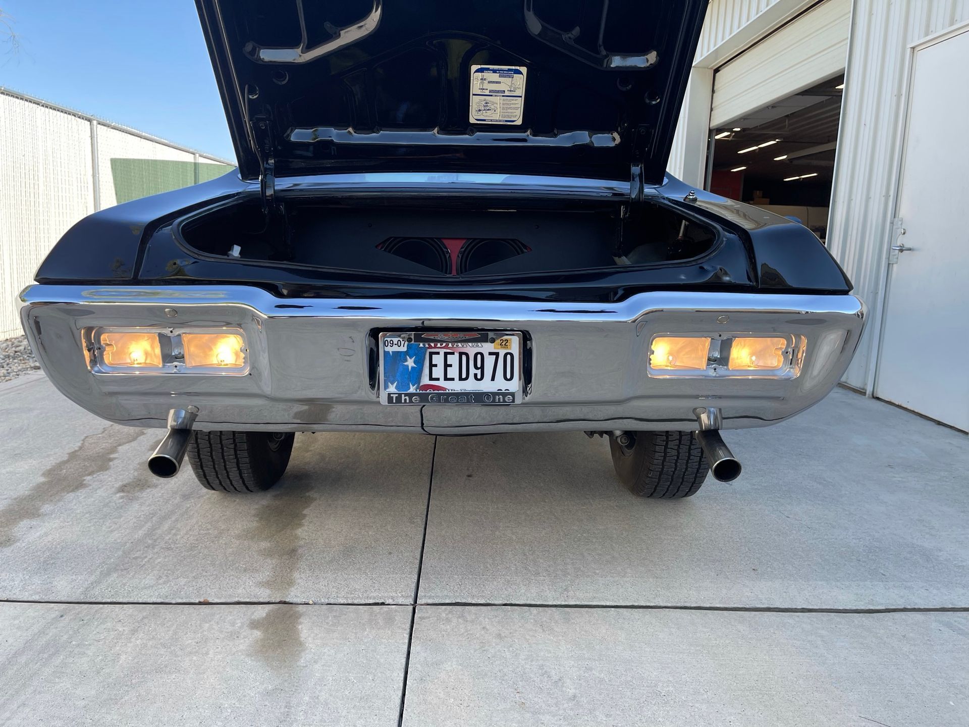 A car with the hood up and a license plate that says ee0970