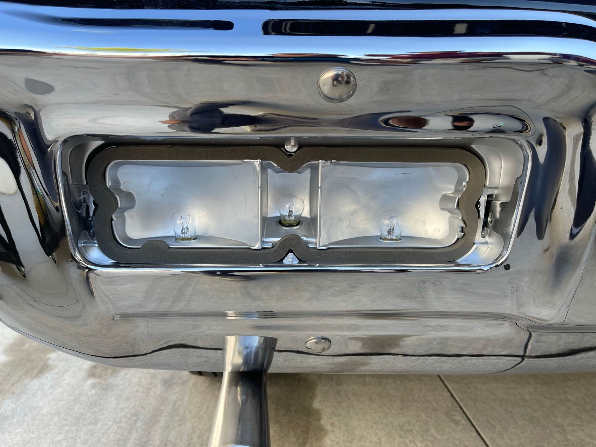 A close up of a chrome bumper with a light on it