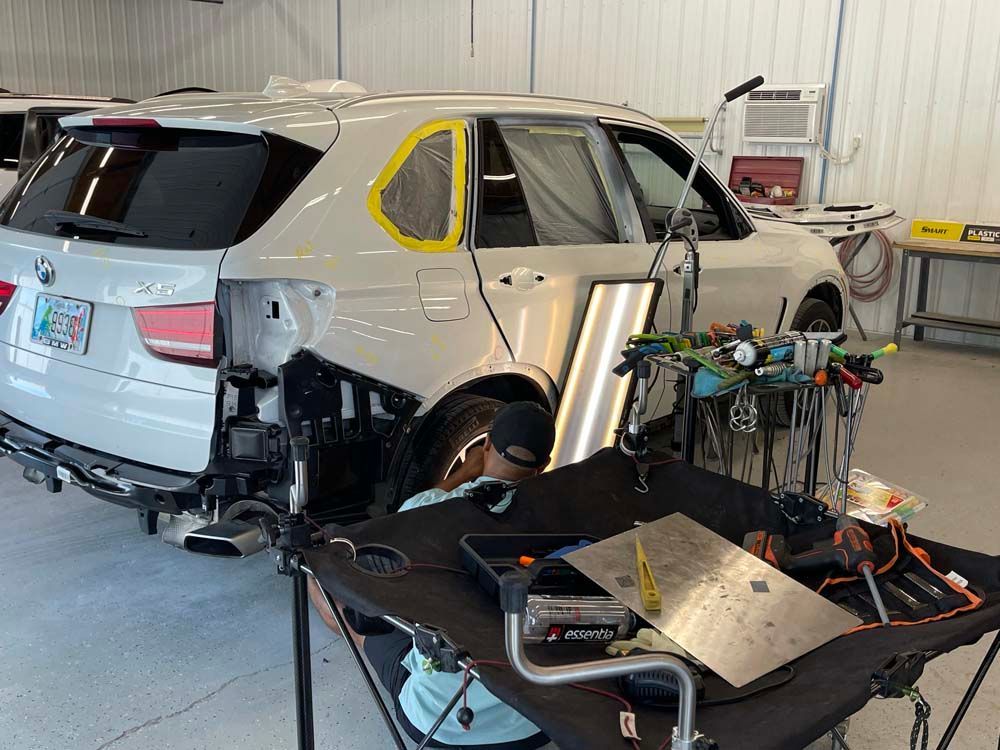 A white suv is being repaired in a garage.