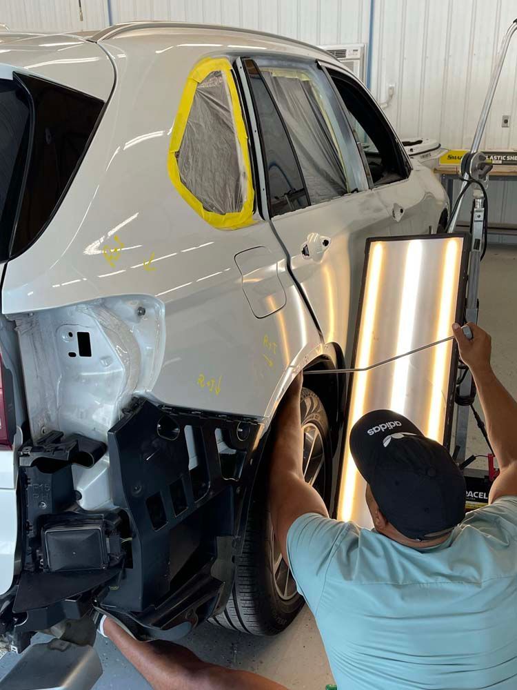 A man is working on a car in a garage.