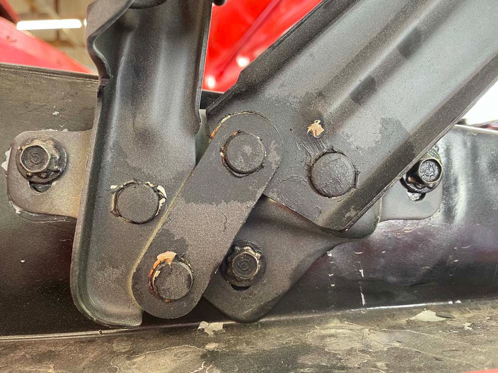 A close up of a metal object with screws on it.