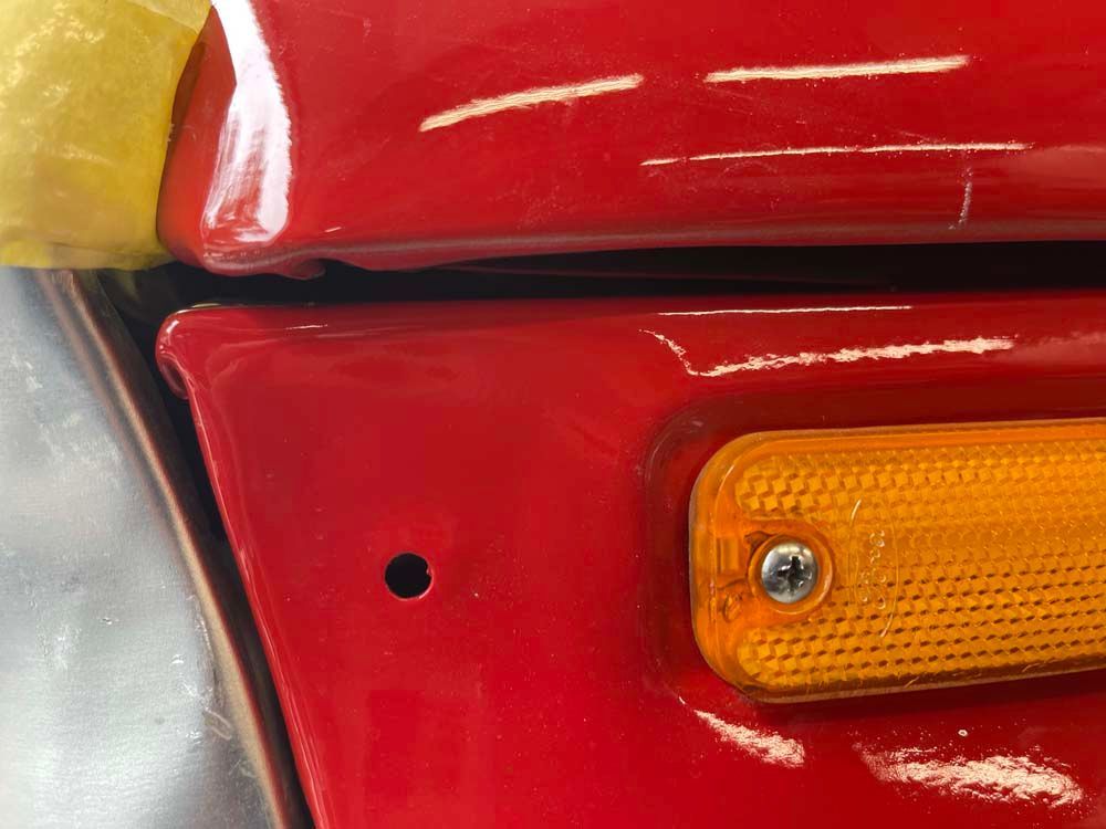 A close up of a red car with a yellow light on it.