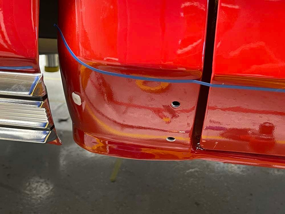 A close up of a red car with holes in it