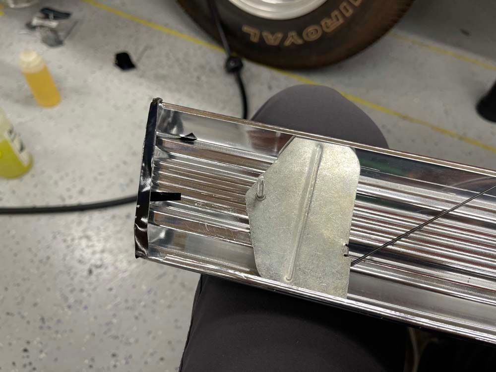 A goodyear tire is sitting on the floor next to a piece of metal