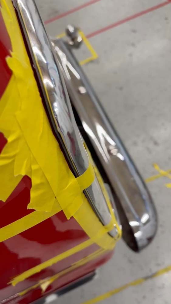 A close up of a red car with yellow tape on it