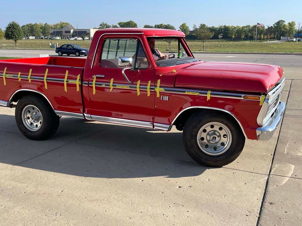 A red truck is parked on the side of the road