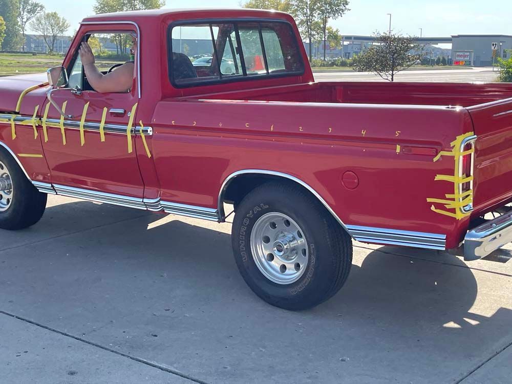 A red truck is parked on the side of the road