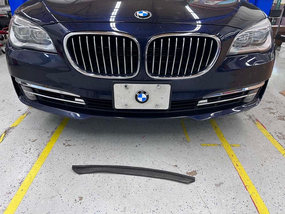 A bmw with a broken bumper is in a garage