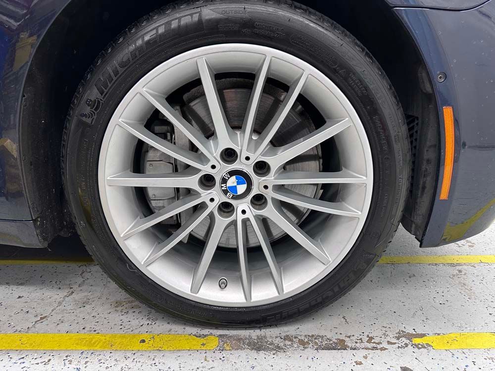 A close up of a bmw wheel in a parking lot.