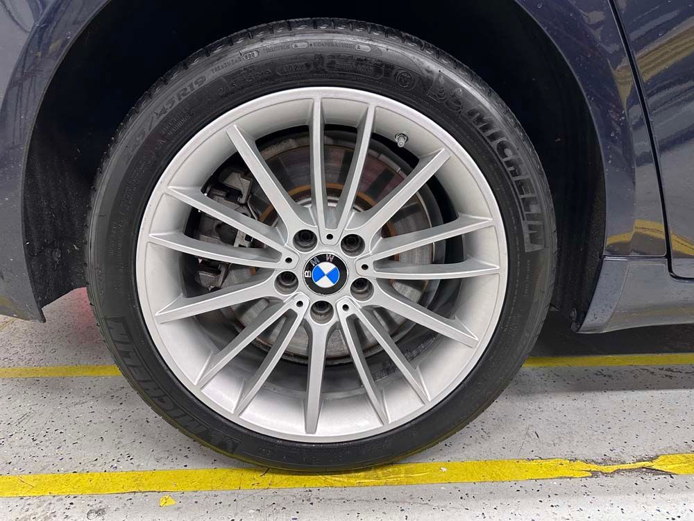 A close up of a bmw wheel in a parking lot.