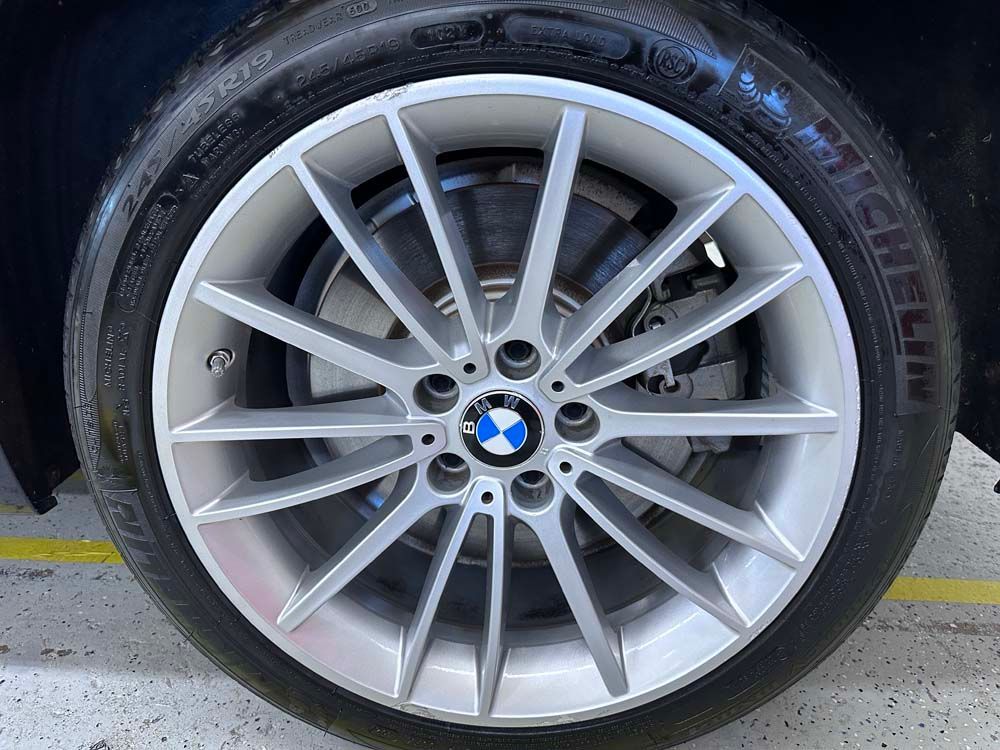 A close up of a bmw wheel with a michelin tire on it.