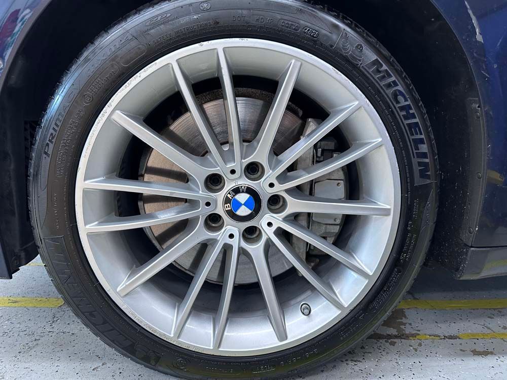 A close up of a bmw wheel with a michelin tire on it.