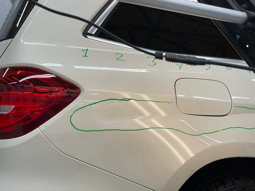 A white car with numbers written on the side of it