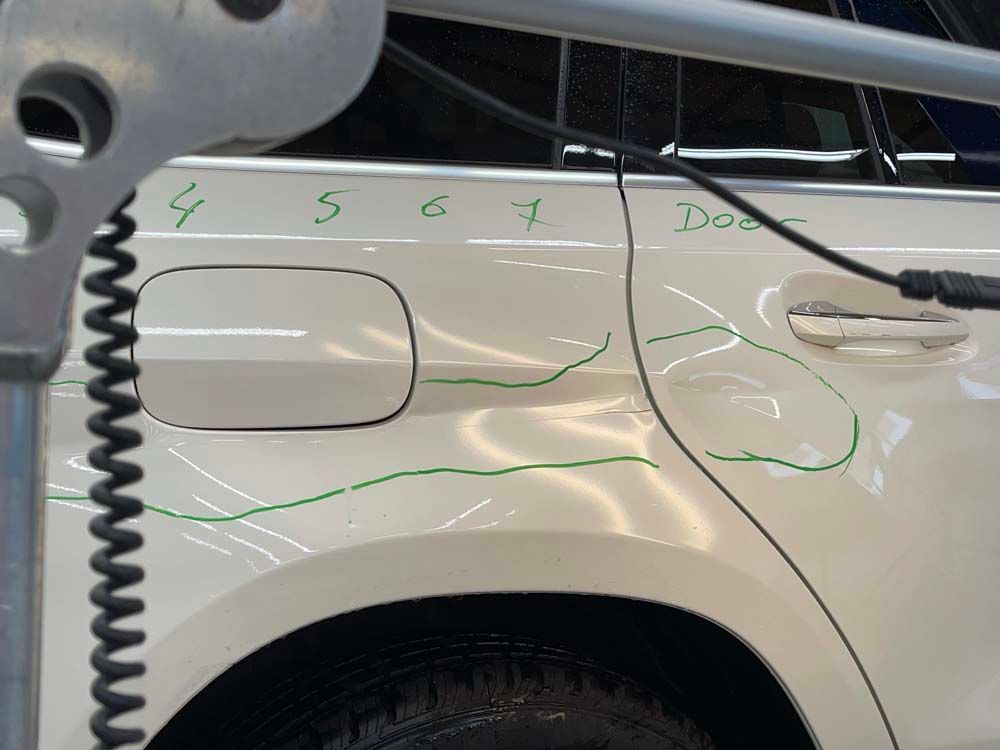 A white car with a green line drawn on it