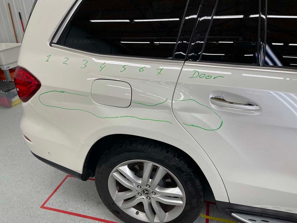 A white suv with numbers written on the side of it