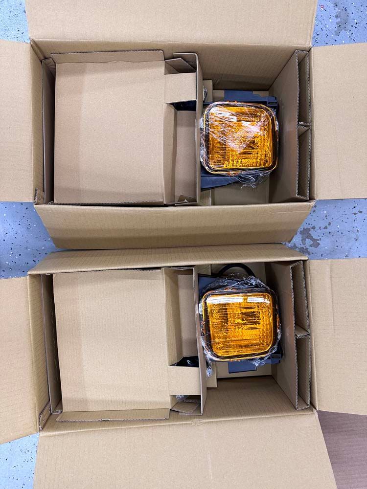 Two cardboard boxes with amber lights inside of them