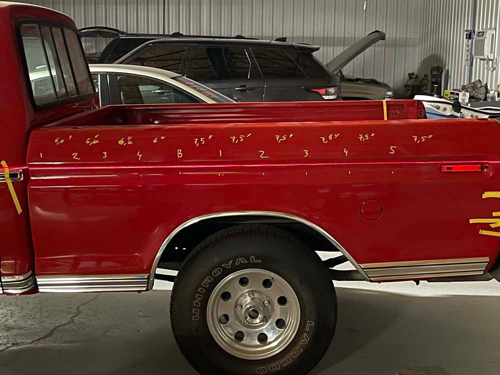 A red pickup truck is parked in a garage.