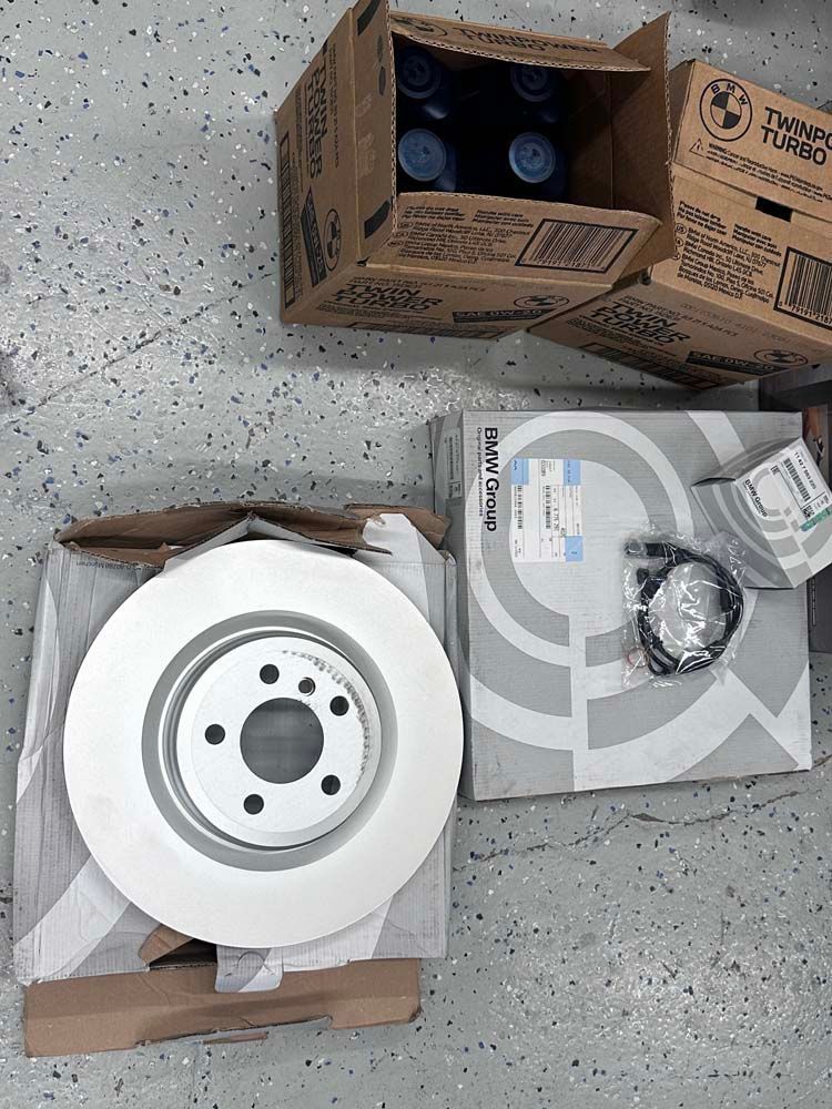 A brake disc is sitting on top of a box next to a box of brake fluid.