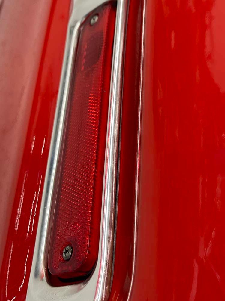 A close up of a red car with a red tail light.