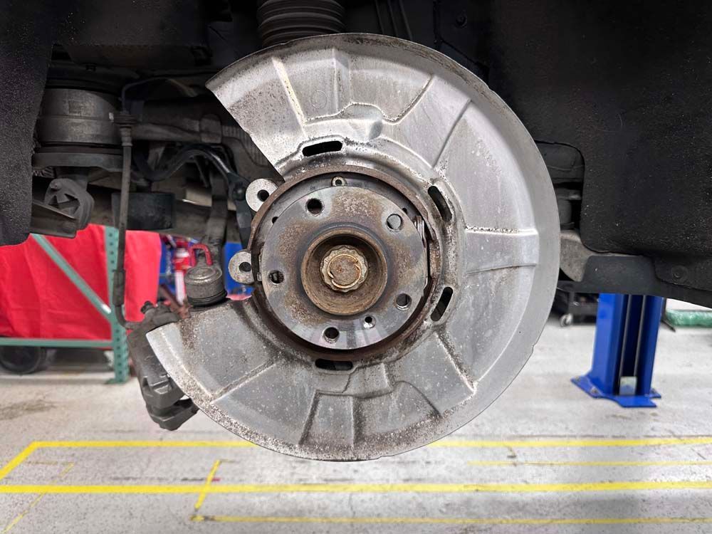 A close up of a brake disc on a car in a garage.