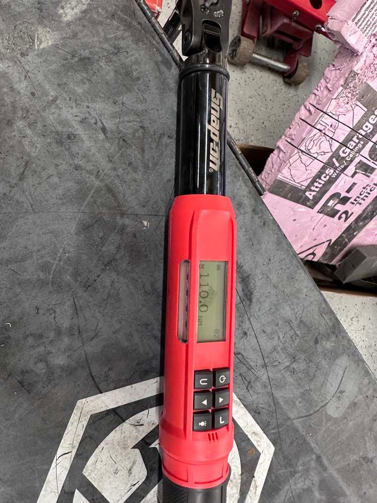 A digital torque wrench is sitting on a table.