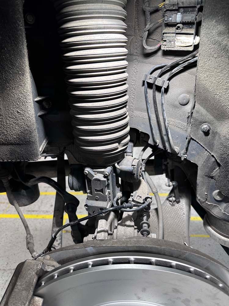 A close up of a car 's suspension and brake system.