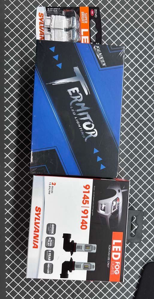 Two boxes of sylvania led bulbs are sitting on top of each other on a table.