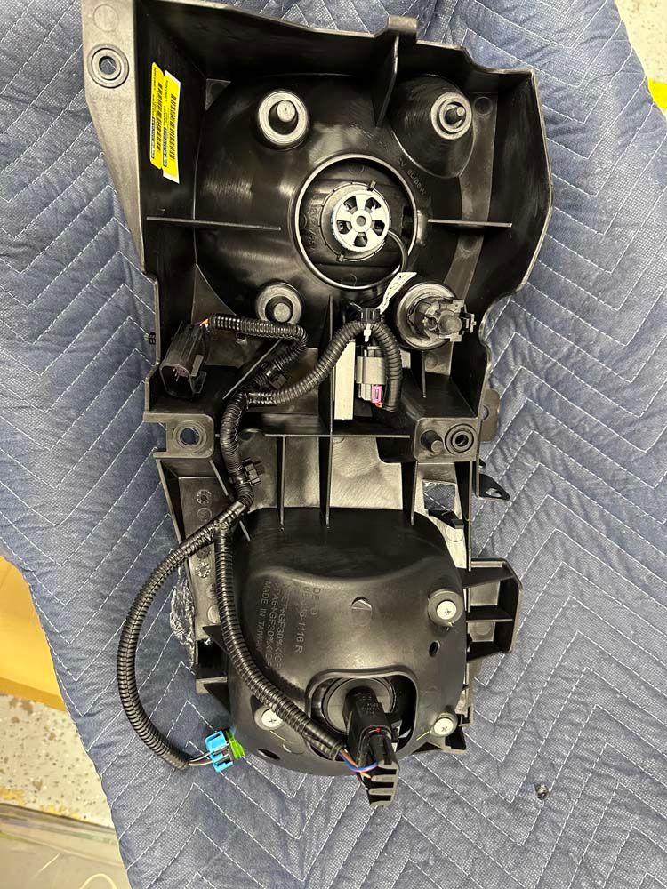 A headlight is sitting on top of a blue blanket on a table.