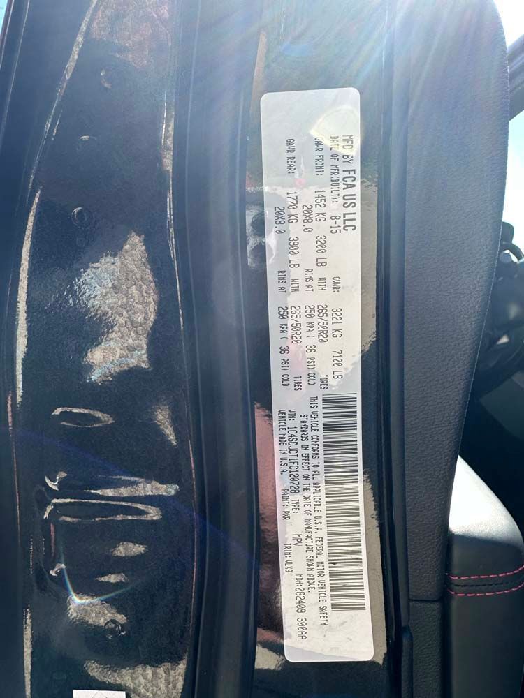 A black car with a sticker on the door that says ' jeep ' on it