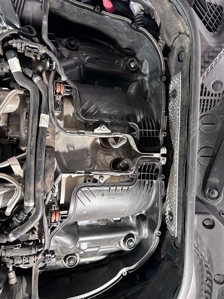 A close up of a car engine with the hood open.