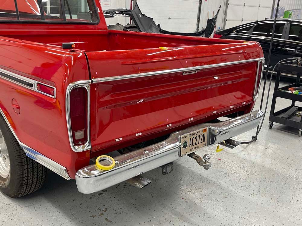 A red truck with a new york license plate is parked in a garage.