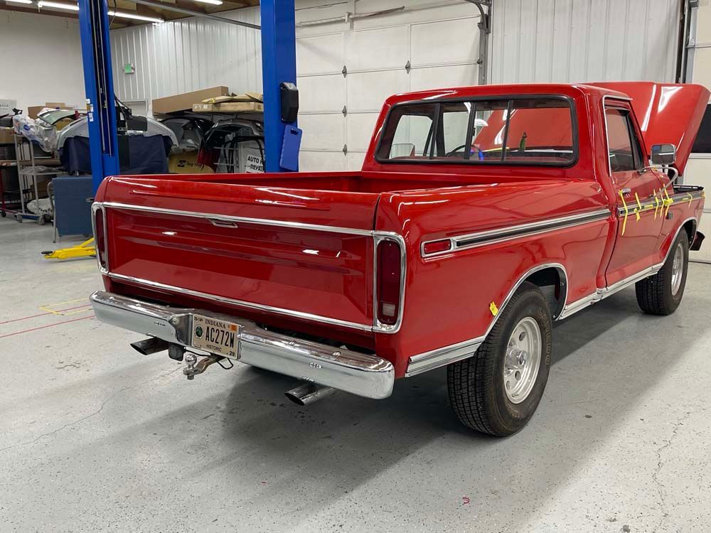 A red pickup truck is parked in a garage.