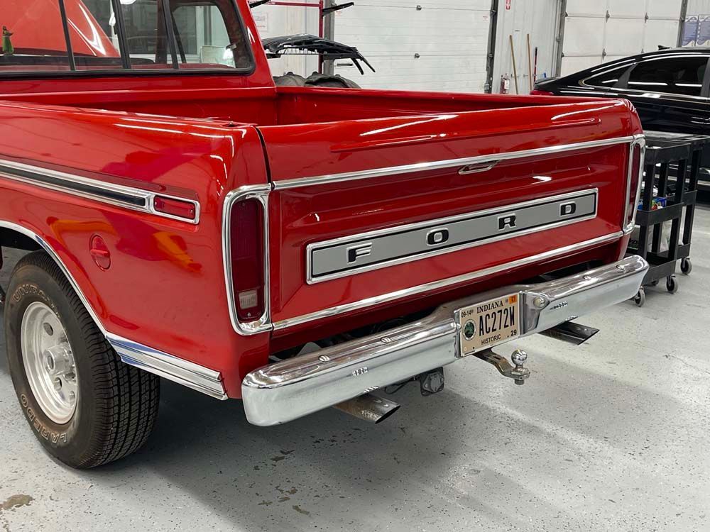 A red ford truck is parked in a garage.