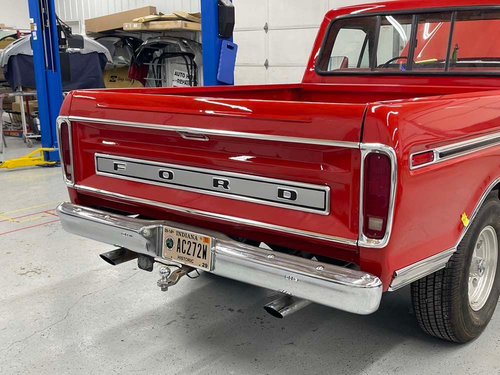 A red ford truck is parked in a garage.